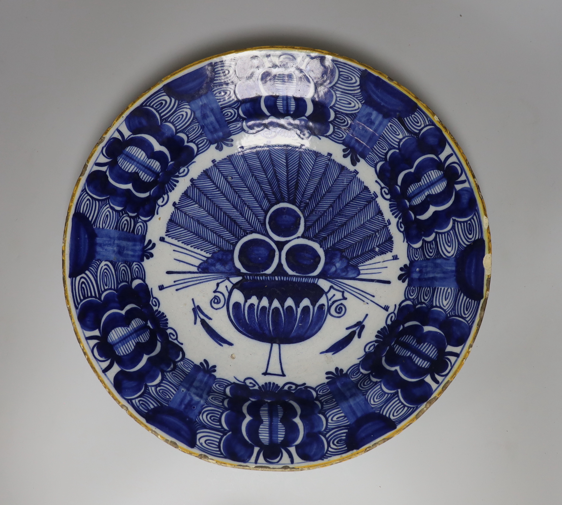 A Dutch Delft blue and white dish, c.1760, painted with the ‘Peacock’ pattern inside and ochre rim, BP mark in blue, rim chips